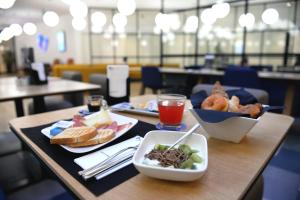 a table with two plates of food and a bowl of food at Air Rooms Rome Airport by HelloSky in Fiumicino