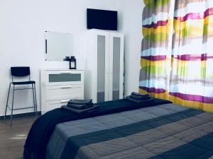 バレストラーテにあるCasa Vacanze Nicoleのベッドルーム1室(カラフルなカーテン付きのベッド1台付)