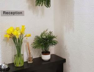 two vases with yellow flowers on a black table at The Blue Mantle in Wellington