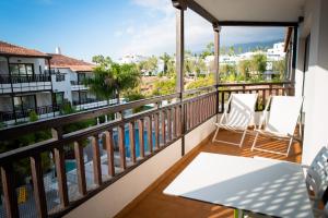 a balcony with two chairs and a view of a pool at Vanilla Garden Boutique Hotel - Adults Only in Playa de las Americas