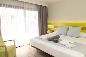 a bedroom with a large white bed with a green headboard at Vanilla Garden Boutique Hotel - Adults Only in Playa de las Americas