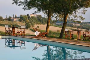 un reflejo de mesas y sillas en una piscina en Château de Salettes, en Cahuzac-sur-Vère