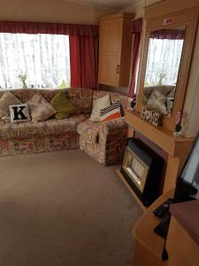 a living room with a couch and a fireplace at 6 Berth Golden Sands Ingoldmells Sahara in Ingoldmells