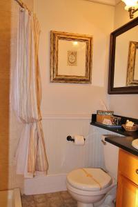 a bathroom with a toilet and a sink and a mirror at Youngtown Inn in Youngtown