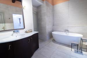 a bathroom with a tub and a sink and a bath tub at Posada Los Condestables Hotel & Spa in Villalpando