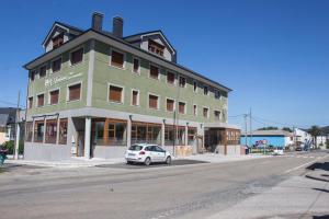 biały samochód zaparkowany przed budynkiem w obiekcie O Vendaval Hostal Restaurante w mieście Barreiros