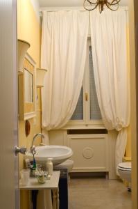 a bathroom with a sink and a toilet and a window at Piano8 in Asola