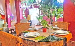 stół z krzesłami oraz stół z talerzami i kieliszkami w obiekcie 3BR Thai Style Home w Pattaya South