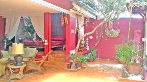 una sala de estar con paredes rojas y un árbol en 3BR Thai Style Home en Pattaya South
