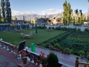 a garden with plants and flowers and mountains in the background at Ladakh Himalayan Retreat in Leh