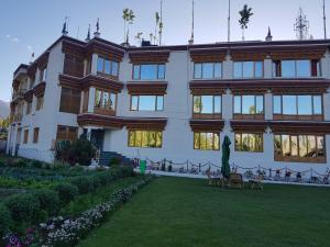 un grande edificio con un prato di fronte di Ladakh Himalayan Retreat a Leh