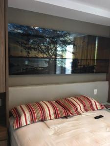 a bedroom with a bed with a painting on the wall at In Mare Bali Resort 127 in Parnamirim