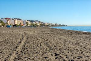 una spiaggia con impronte di piedi nella sabbia e nell'oceano di Nuevo Rincon a Rincón de la Victoria