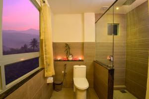 a bathroom with a toilet and a window with a view at Mistletoe Homestay & Cafe in Munnar +119 photos
