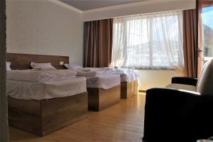 a hotel room with two beds and a window at Ketino's Home in Stepantsminda