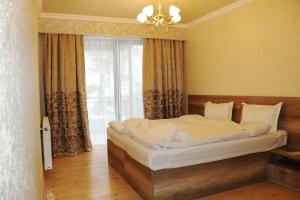 uma cama num quarto com uma grande janela em Ketino's Home em Kazbegi