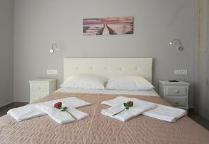 a bed with towels and flowers on top of it at Anastasia's Luxury Apartments in Chania Town