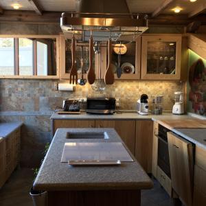 uma cozinha com um balcão com um lavatório e um fogão em Le grenier des rêves em Les Deux Alpes