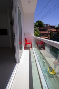 a red chair sitting on top of a balcony at Apart-Hotel Bella Vida Suítes e Apartamentos in Morro de São Paulo