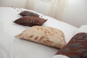 ein Bett mit drei Kissen darauf in der Unterkunft Apartmani Kanjer 1 Delnice in Delnice