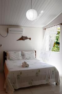a bedroom with a bed with two stuffed animals on it at Pousada Pérola do Atlântico in Ilha de Boipeba