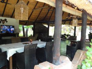a dining room with a white table and chairs at The Royal Sichango Village in Livingstone +28 photos
