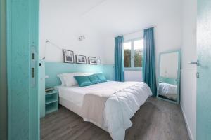 a blue and white bedroom with a bed and a window at Villaggio Orizzonte in Riotorto