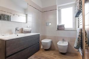 a bathroom with a sink and a toilet and a window at Sunset Home Sperlonga - Allogio per uso turistico Giulia Sabella in Sperlonga