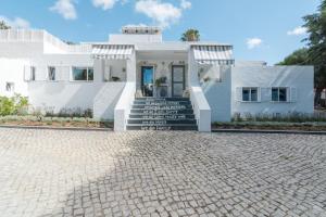 a white house with a brick driveway at Villa Estoril in Estoril