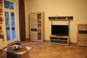 ein Wohnzimmer mit einem Flachbild-TV auf einem Stand in der Unterkunft Ferienwohnung Berthold WG 3 in Blankenburg