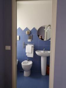 een blauw betegelde badkamer met een toilet en een wastafel bij Hotel La Congiura dei Baroni in Teggiano