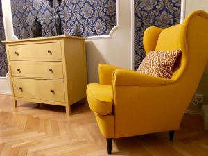 a yellow chair sitting next to a dresser at Apartments im Thüringer Hof in Berlin