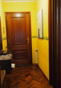 um corredor com uma porta de madeira e paredes amarelas em Cruxa Apartments garaje incluido em Santiago de Compostela