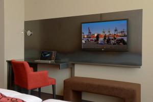 una camera con TV e computer portatile su un tavolo di Hotel Volksschule ad Amburgo
