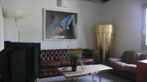 ein Wohnzimmer mit Ledersofa und einem Tisch in der Unterkunft Caspineda Agriturismo in Montebelluna