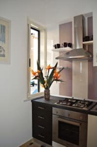 una cocina con fogones y un jarrón de flores en Casa Elena, en Maiori