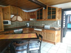 a kitchen with wooden cabinets and a table with chairs at Fachwerkhaus in D 63667 Nidda für 8 bis 12 Personen in Nidda