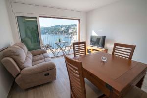 a living room with a table and a chair and a couch at Apartament Cortey in Calella de Palafrugell
