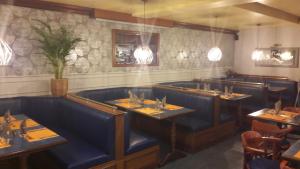 ein Speisesaal mit blauen Sitznischen und Tischen in der Unterkunft Le Maryland in Blanzy