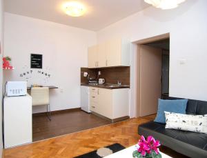 a living room with a couch and a kitchen at Studio apartman Rest Nest in Čakovec