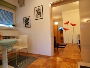Studio apartman Rest Nest في تشاكوفيتش: غرفة معيشة مع طاولة وكراسي وورود حمراء
