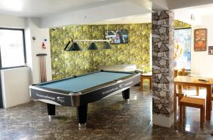 a pool table in a room with a wall at Long Hotel and motobike rental in Ha Giang