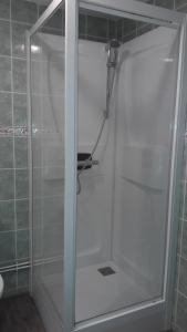 La salle de bains est pourvue d'une douche avec une porte en verre. dans l'établissement Le Maryland, à Blanzy