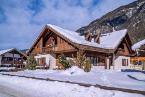 a log home in the snow with a mountain at Alpin Apart Maurer in Längenfeld