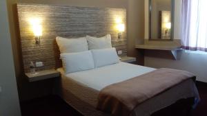 蒙克洛瓦Hotel Royal Inn的一间卧室配有一张带白色枕头的床和砖墙 更多14张照片