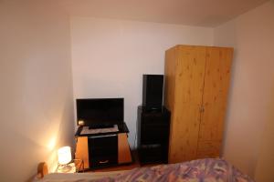 Schlafzimmer mit einem Bett, einem TV und einem Schrank in der Unterkunft Private Room - Messe Nord in Hannover