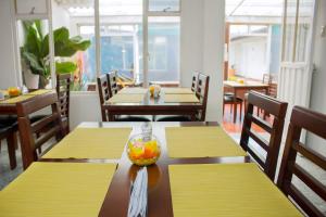 a restaurant with tables and chairs with a bowl of fruit on it at Hotel Normandia Gold in Bogotá