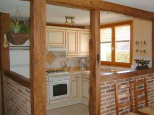 a kitchen with white cabinets and a stove top oven at la roseraie in Caumont