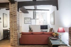 a living room with a red couch and a television at Campo de' Fiori apartment in Rome