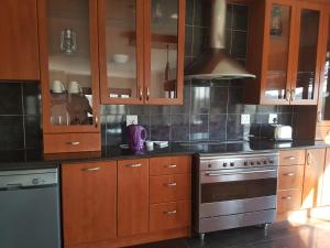 a kitchen with wooden cabinets and a stove at Tyday Accommodation in Port Elizabeth